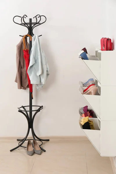 Shoe cabinet with footwear in room. Storage ideas