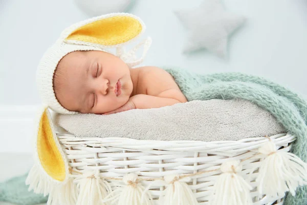 可爱的新生儿戴着兔子耳帽在婴儿窝室内 — 图库照片