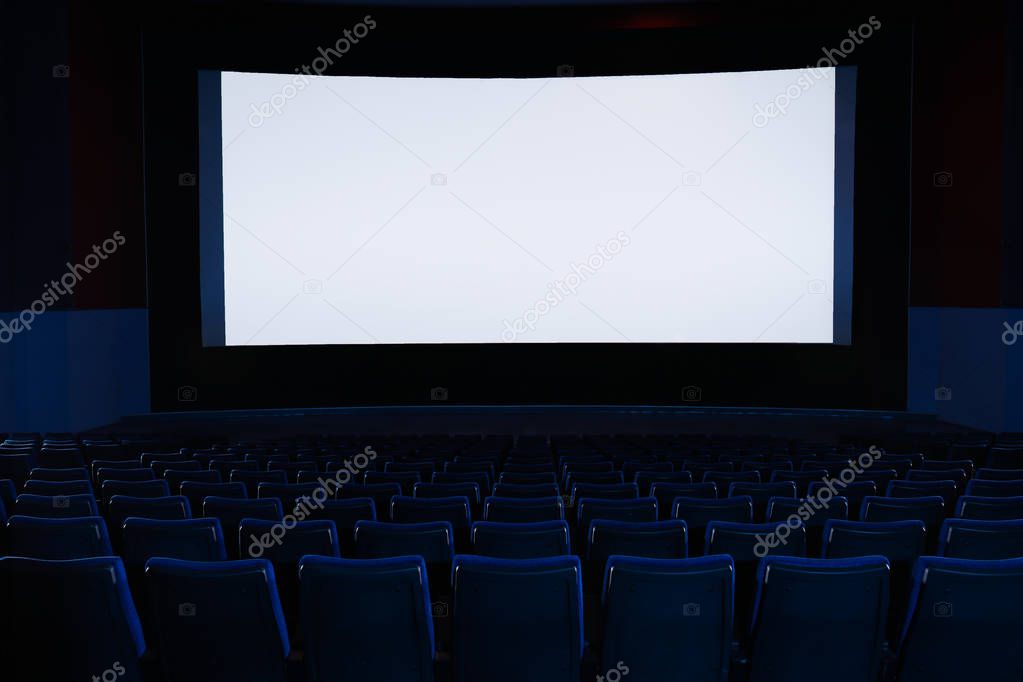 Empty cinema with large screen and comfortable chairs. Space for text