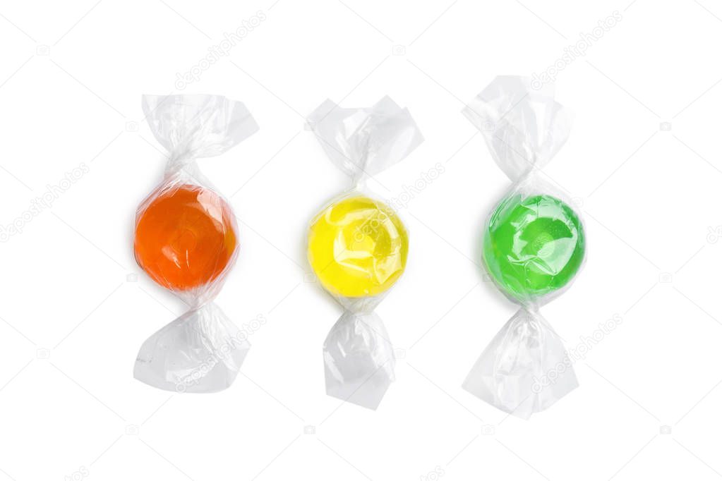 Different delicious colorful candies on white background, top view