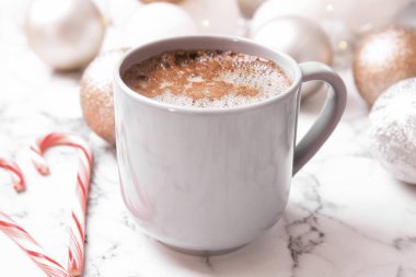 Fincan sıcak kış içki, şekerler ve Noel topları mermer masada. Rahat sezon