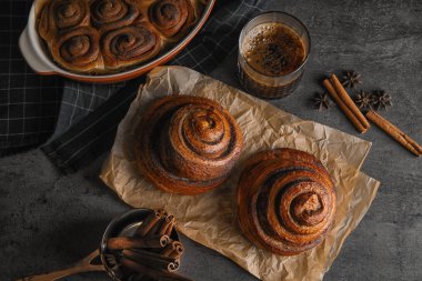 Gri arka plan üzerinde taze pişmiş rulo tarçın ile düz yatıyordu kompozisyon