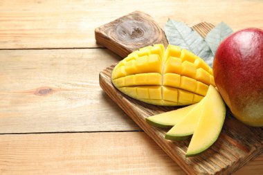 Ahşap masa üzerinde taze mango ile yönetim kurulu. Metin için yer