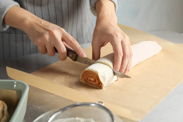 Frau Schneidet Teig Für Zimtröllchen Auf Pergament Tisch Nahaufnahme — Stockfoto