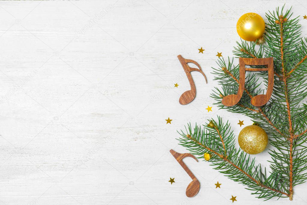 Flat lay composition with Christmas decor, music notes and space for text on white wooden background