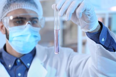 Laboratuvar test tüpü ile çalışan genç bilim adamı. Kimyasal analiz
