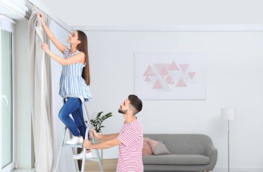 Genç çift pencere perde odasında asılı. Metin için yer