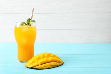 Taze mango içki ve mavi ahşap masa kesilmiş meyve. Metin için yer
