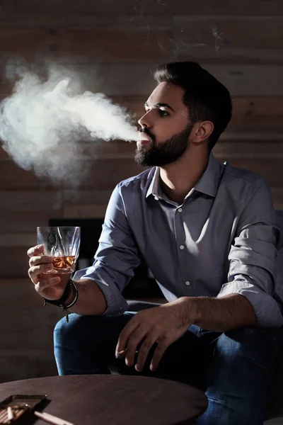 Hombre Con Vaso Whisky Cigarro Sentado Mesa Interior —  Fotos de Stock