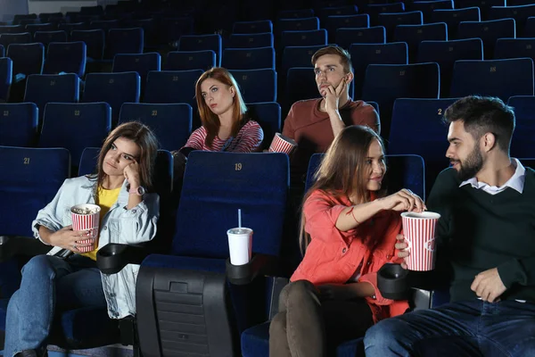 Young people watching movie in cinema theatre