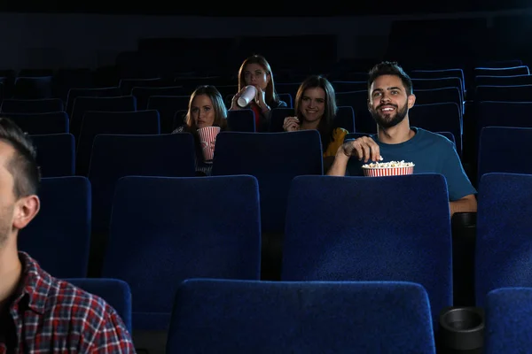 Young people watching movie in cinema theatre