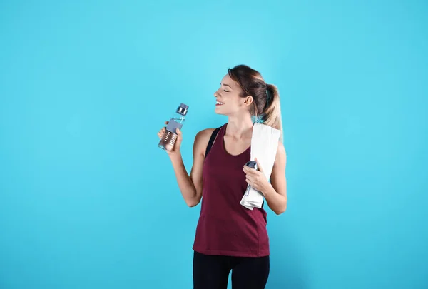 Schöne Junge Frau Sportbekleidung Mit Handtuch Und Wasserflasche Auf Farbigem — Stockfoto