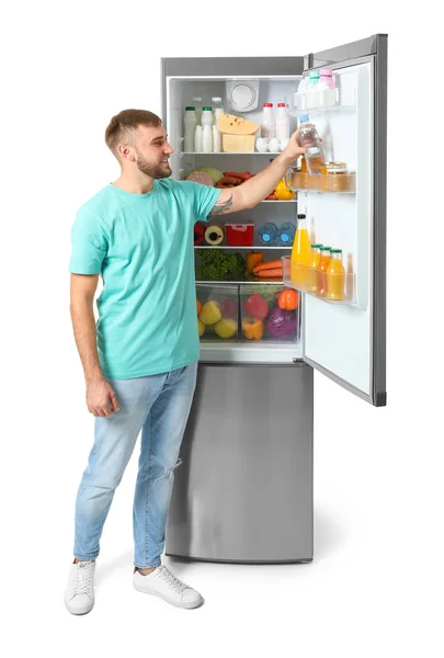 Молодой Человек Берет Бутылку Воды Холодильника Белом Фоне — стоковое фото