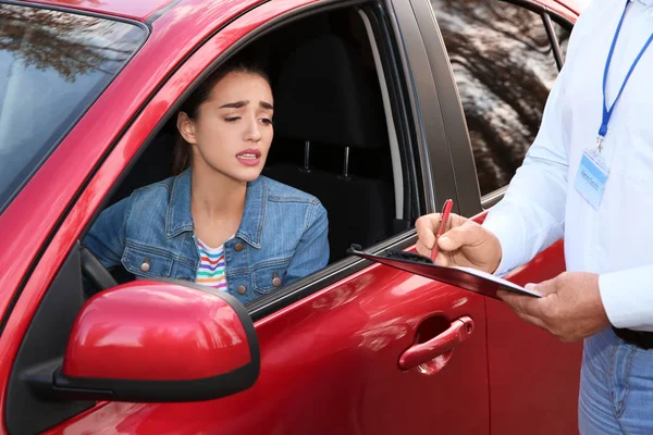 Instructor near woman in car, outdoors. Passing driving license exam