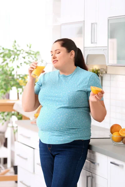 Толстая Женщина Пьет Свежий Сок Апельсин Кухне Здоровое Питание — стоковое фото