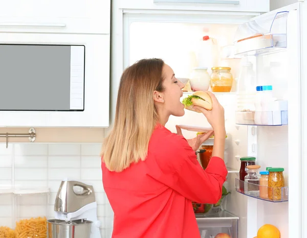 Mujer Joven Hambrienta Comiendo Sándwich Cerca Refrigerador Abierto Cocina Dieta — Foto de Stock