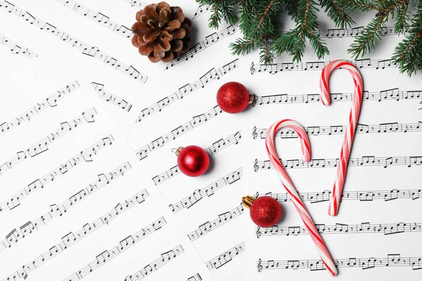 Baston şekerler ve müzik sayfaları, üstten görünüm Noel topları ile kompozisyon