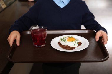 Okul kantininde, portre sağlıklı yemek tepsisiyle tutan çocuk