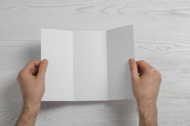 Boş broşür görünümünün üzerinde ahşap arka plan üzerinde olan adam. Tasarım için alay