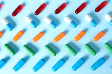 Düz renkli arka plan üzerinde farklı parlak hapları yatıyordu