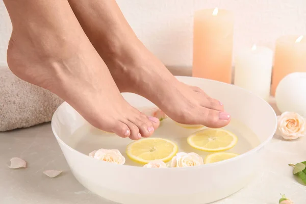 Žena Její Nohy Nádoby Vodou Růže Plátky Citronu Podlaze Closeup — Stock fotografie