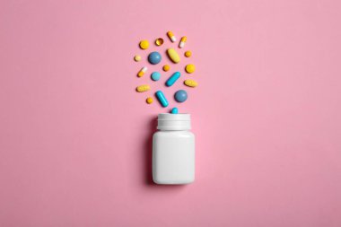 Şişe ve hapları renk arka plan üzerinde düz yatıyordu kompozisyonu