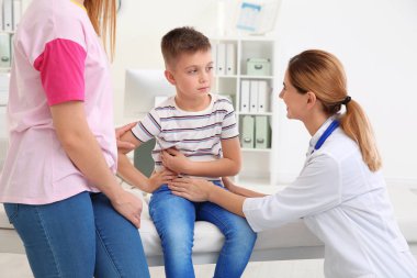 Anne ve çocuk doktoru ziyaret oğlu. Doktor hastanede hasta ile çalışma