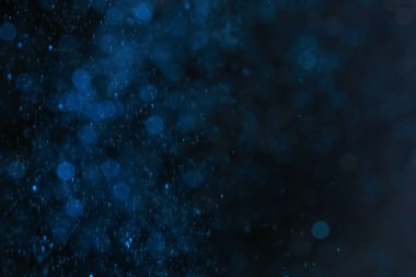 Glitter koyu arka plan üzerinde renkli. Bokeh etkisi