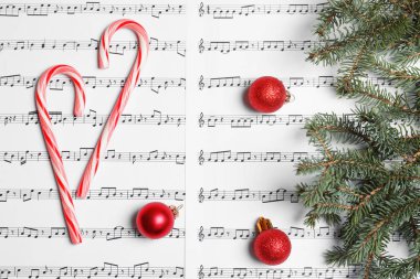 Baston şekerler ve müzik sayfaları, üstten görünüm Noel topları ile kompozisyon