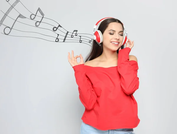 Junge Frau Mit Kopfhörern Und Musiknoten Vor Hellem Hintergrund Raum — Stockfoto