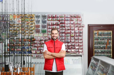 Spor salonu içinde balık tutmak için ekipmanlar ile vitrin yakın duran satıcısı