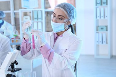 Sıvı örnekleri ile test tüpleri üzerinde tutan genç bilim adamı arka plan bulanık. Laboratuvar analiz