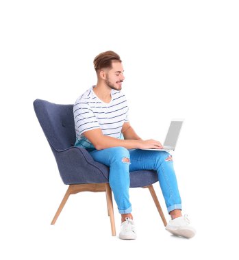 Beyaz arka plan üzerinde koltuk içinde laptop ile yakışıklı genç
