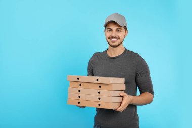 Genç kurye ile pizza kutuları üzerinde renk arka plan, metin için yer. Gıda dağıtım hizmeti