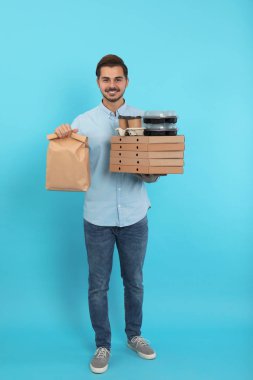 Genç kurye ile renk arka plan üzerinde farklı sipariş. Gıda dağıtım hizmeti
