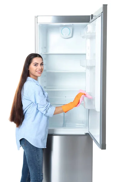 Молодая Женщина Моет Холодильник Тряпкой Белом Фоне — стоковое фото