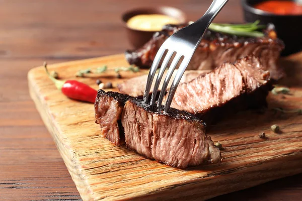 Garpu Dengan Steak Panggang Lezat Atas Meja Kayu — Stok Foto