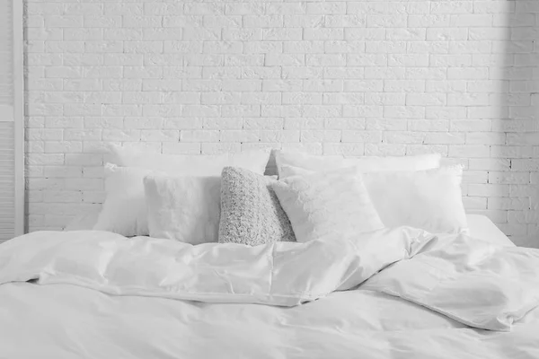 ベッド枕と室内で白いレンガの壁の近くに毛布 スタイリッシュなインテリア — ストック写真