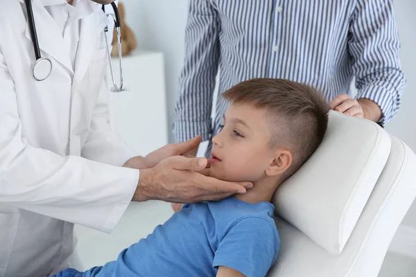 Father and son visiting pediatrician. Doctor working with patient in hospital