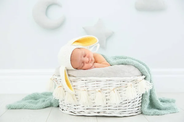 可爱的新生儿戴着兔子耳帽在婴儿窝室内 — 图库照片