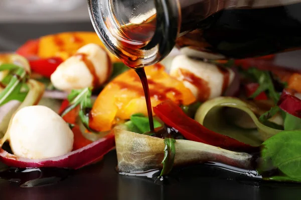 クローズ アップ野菜サラダにバルサミコ酢を注ぐ — ストック写真