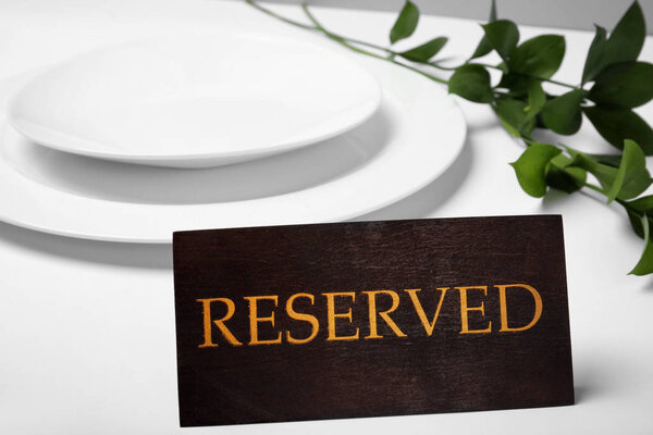 Elegant table setting and RESERVED sign in restaurant