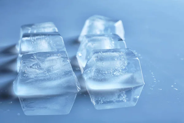 Transparent ice cubes on color mirror surface