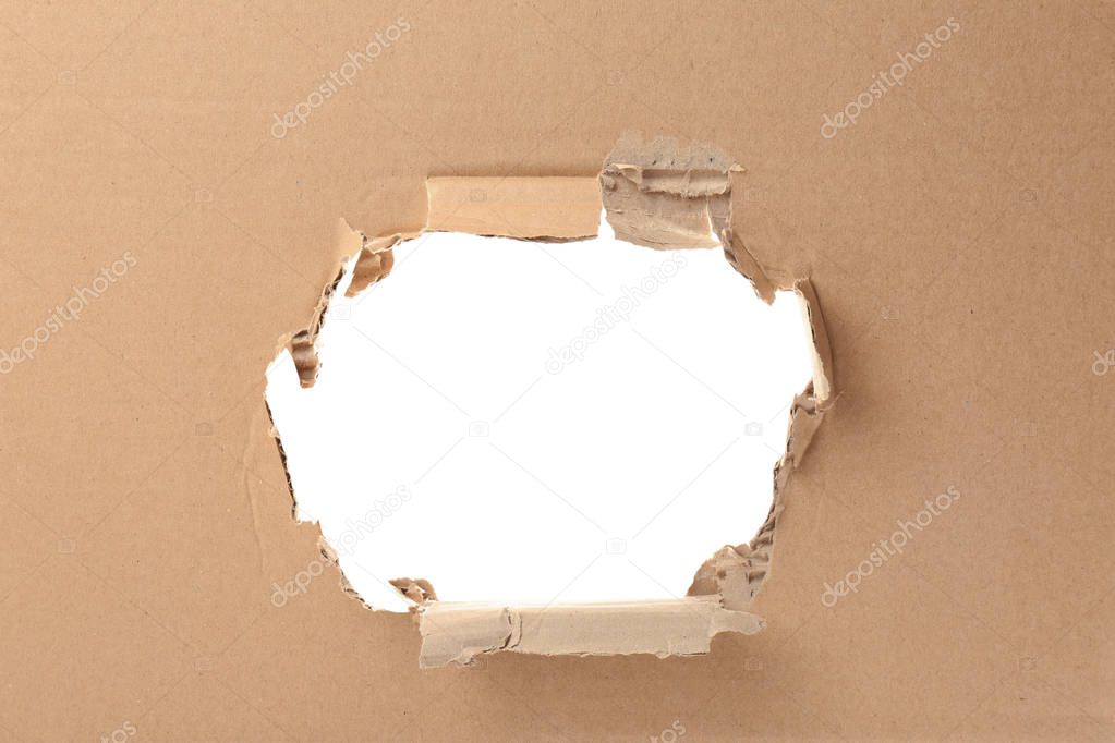 Hole in cardboard on white background. Recyclable material