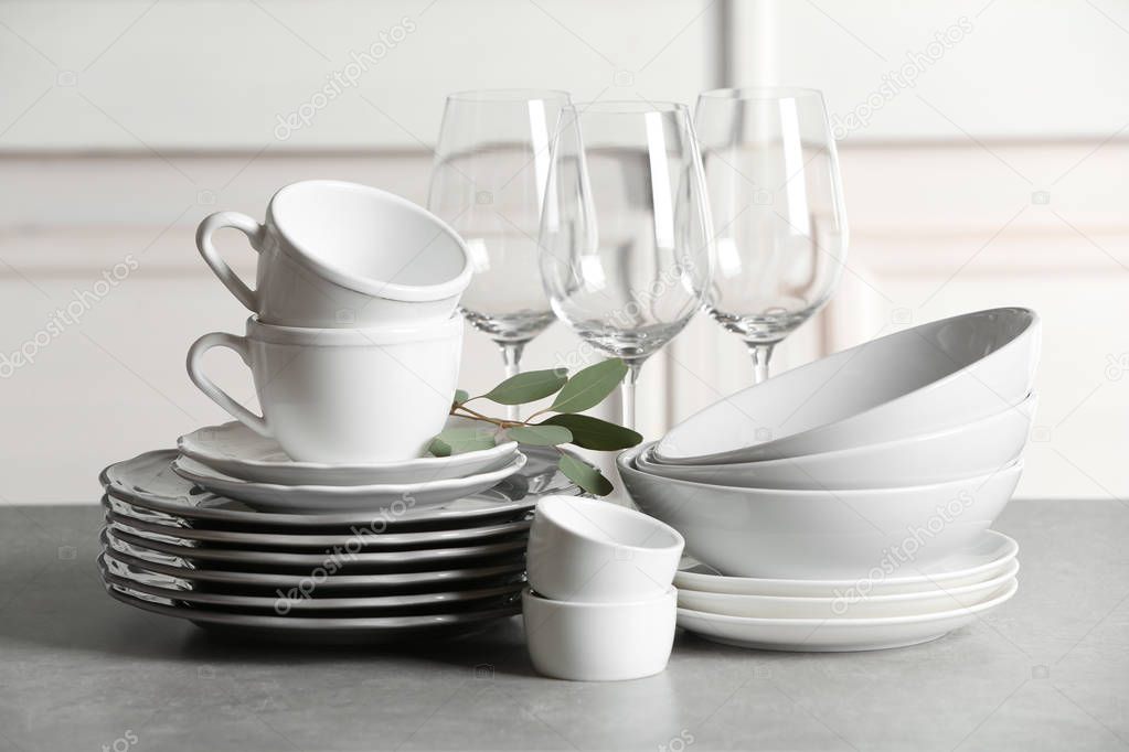 Set of clean dishes on table against blurred background