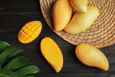 Ahşap arka plan üzerinde mango ile düz yatıyordu kompozisyon