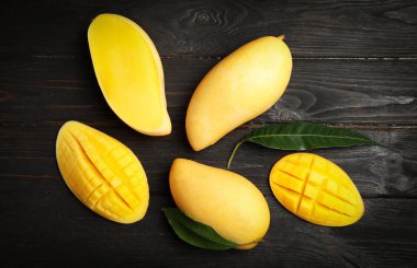 Ahşap arka plan üzerinde mango ile düz yatıyordu kompozisyon