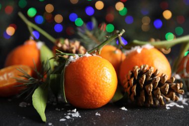 Olgun mandalina, yapay kar ve arka plan bulanık Noel ışıkları