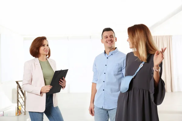 Real estate agent showing new apartment to young couple