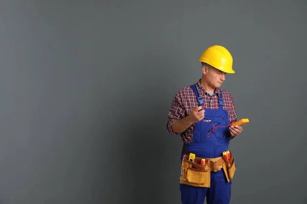 Elektricien Met Multimeter Dragen Van Uniform Grijze Achtergrond Ruimte Voor — Stockfoto